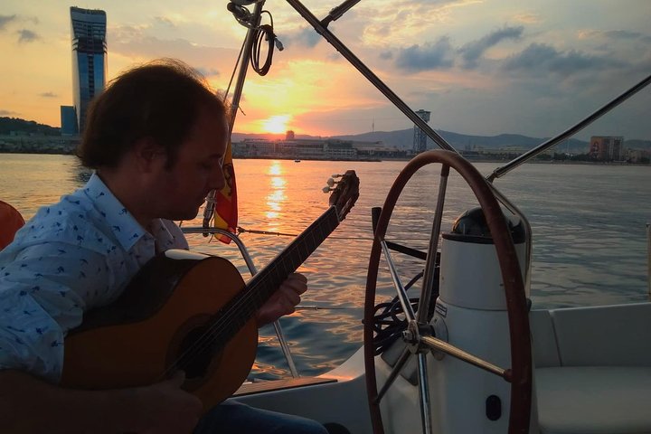 Our guitar Maestro playing the guitar facing the sunset while on board the sailing yacht