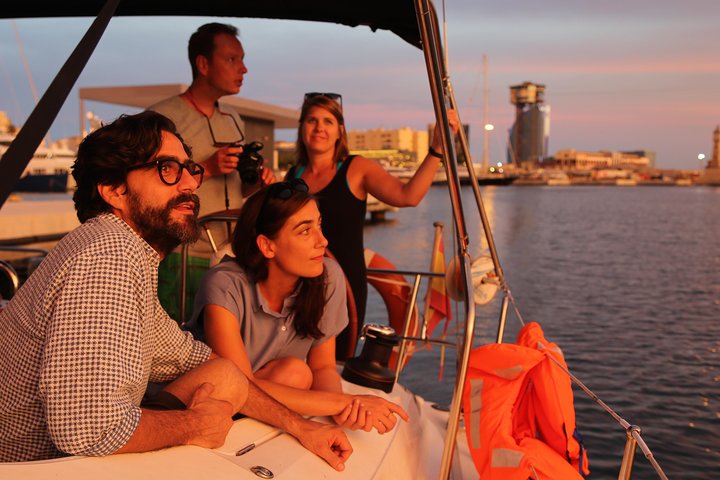 A group of people in awe in front of the sunset, from the sailing yacht